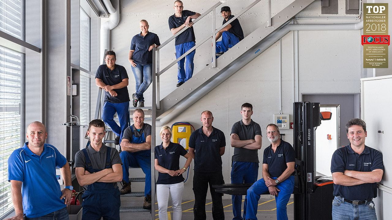 Gruppenbild von Ensinger Mitarbeitern in einer Werkshalle